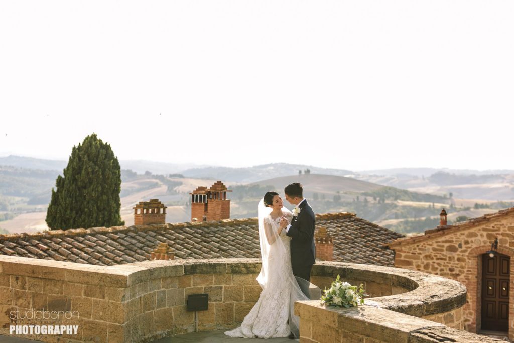 Bride groom share some love. Wedding portrait in Tuscany countryside at Tenuta di Castelfalfi
